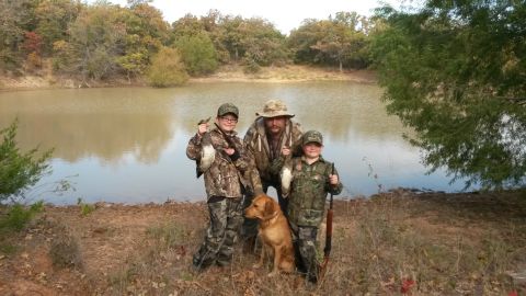 1993 Ford Bronco - Hunters and their dog pose by a lake after a successful hunt.
