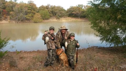 1993 Ford Bronco - A family poses with their hunting dogs and ducks by a lake.