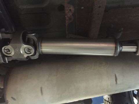 1995 Ford Bronco - Underside view of a driveshaft and exhaust system, with visible rust on the frame.
