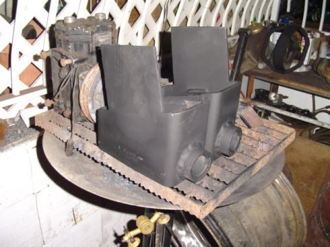 1993 Ford Bronco - Two freshly painted flat-black fabricated steel brackets or spring perches sit on a rusty grate laid over a barrel, with an air conditionin…