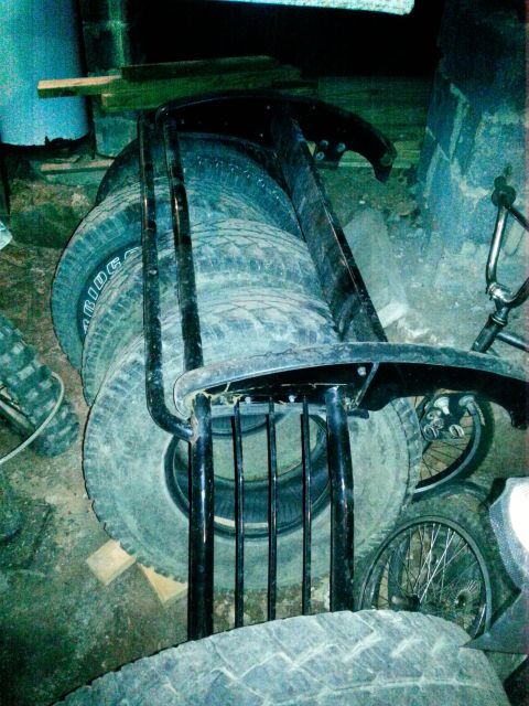 1994 Ford Bronco - A collection of tires and a metal frame are stored indoors, with some bicycle wheels visible.