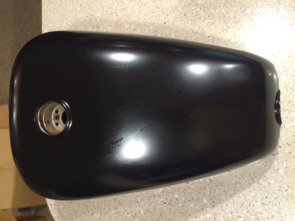 Black motorcycle fuel tank with two mounting points visible