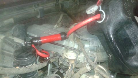 1996 Ford Bronco - A fluid transfer pump is being used to service the oil filter on a vehicle's engine.