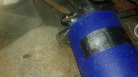 1996 Ford Bronco - Close-up of a blue oil filter with a metal label displaying installation instructions and warnings.
