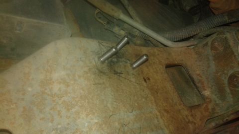 1996 Ford Bronco - Close-up of rusted metal frame with two bolts, one longer than the other.