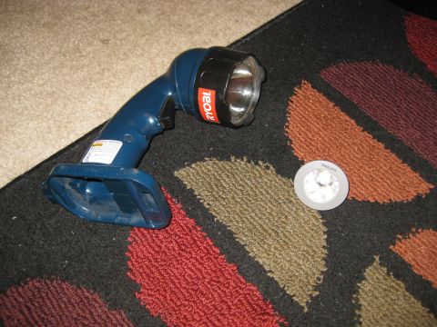 1994 Ford Bronco - A Ryobi flashlight and a Philips light are placed on a rug, with no vehicle visible.