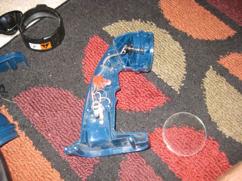 1994 Ford Bronco - Disassembled Ryobi flashlight parts laid out on a rug, showing the internal wiring and spring mechanism.