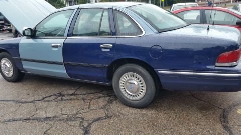 1991 Ford LTD Crown Victoria - Photograph of the full side profile of a two-tone blue and silver Crown Victoria sedan, not a technical document.