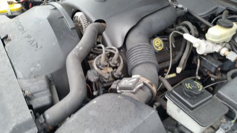 1991 Ford LTD Crown Victoria - Photograph of an engine compartment with intake plenum, hoses, and brake master cylinder, not a technical document.