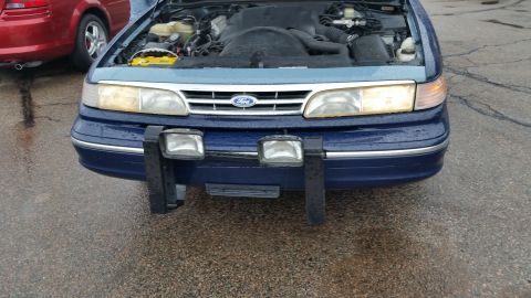 1991 Ford LTD Crown Victoria - Photo of a blue Ford Crown Victoria front end with hood raised, not a technical document.