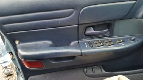 1991 Ford LTD Crown Victoria - Photo of a vehicle door panel with window and lock controls, not a technical document.