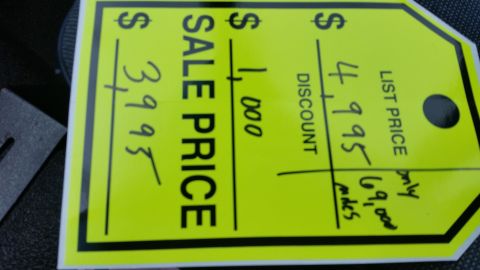 1991 Ford LTD Crown Victoria - Handwritten yellow dealer price tag showing list and sale price, not a technical document.