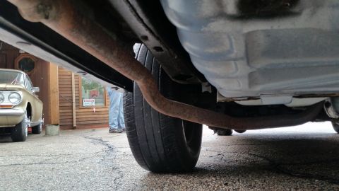 1991 Ford LTD Crown Victoria - Photo of a vehicle undercarriage with exhaust and tire, not a technical document.