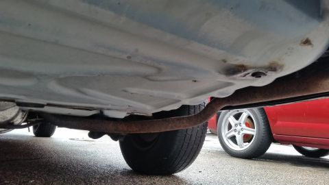 1991 Ford LTD Crown Victoria - Photo of a vehicle underbody with rusty exhaust, not a technical document.
