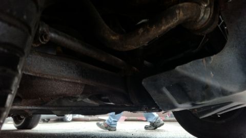 1991 Ford LTD Crown Victoria - Photo of a vehicle undercarriage with rusty exhaust, not a technical document.