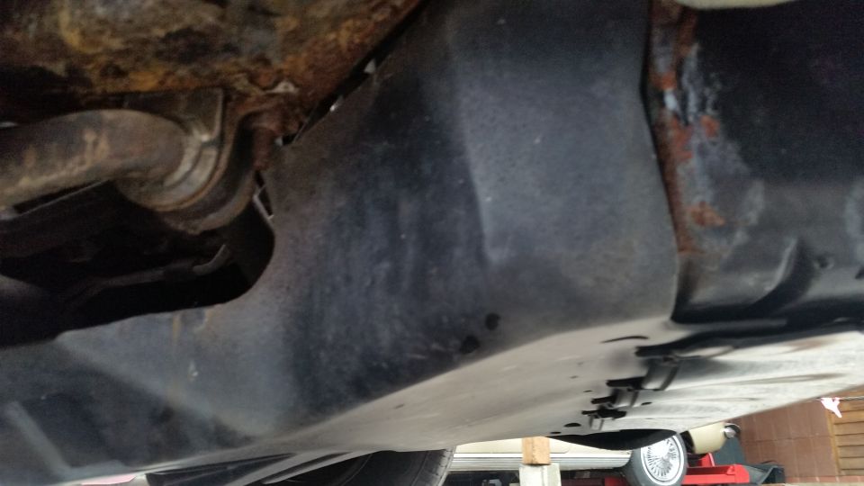 Underbody view of floor pan and frame rail with rust
