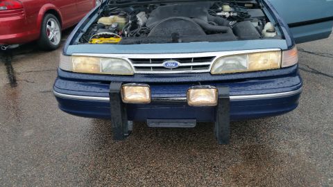 1991 Ford LTD Crown Victoria - Photo of a blue Ford Crown Victoria front end with hood raised, not a technical document.