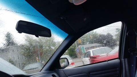 1991 Ford LTD Crown Victoria - Photo through a rain-covered windshield and window, not a technical document.