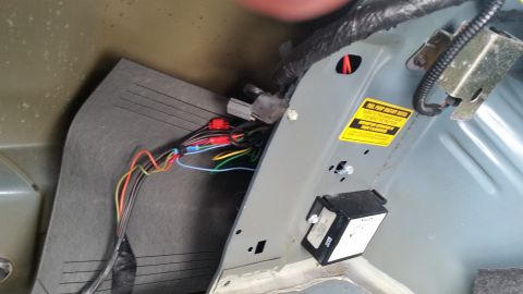 1991 Ford LTD Crown Victoria - Photo of a trunk-mounted electrical component with color wires and a small warning sticker, not a diagram.