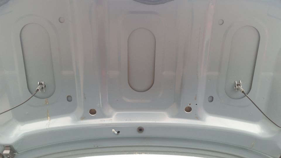 Underside of a painted hood or deck lid showing stamped reinforcement ribs