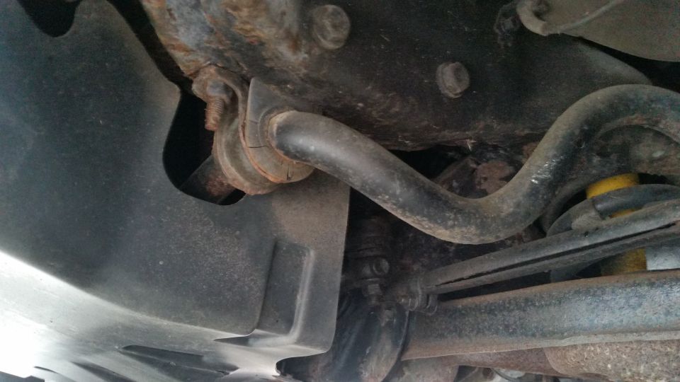 Undercarriage view of a sway bar, control arm and suspension components