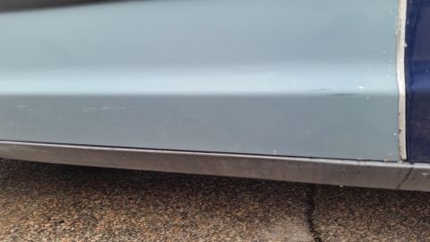 1991 Ford LTD Crown Victoria - Close-up photograph of a sedan's lower door and rocker panel, not a technical document.
