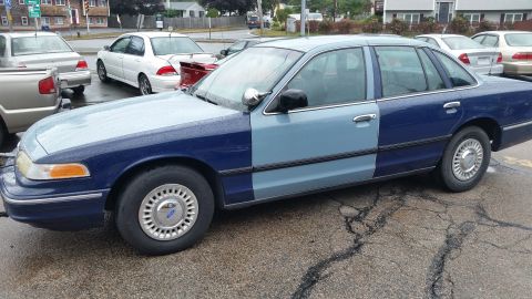 1991 Ford LTD Crown Victoria - Photograph of a two-tone blue Ford Crown Victoria sedan in a parking lot, not a technical document.