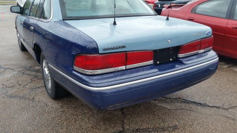 1991 Ford LTD Crown Victoria - Rear view of a two-tone Ford Crown Victoria, parked next to a red car.