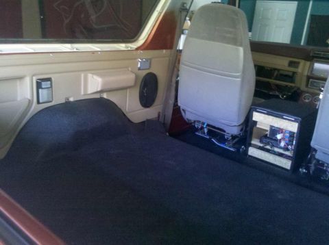 1982 Ford Bronco - Interior view of a vehicle, showing carpeted flooring, a speaker, and seats.