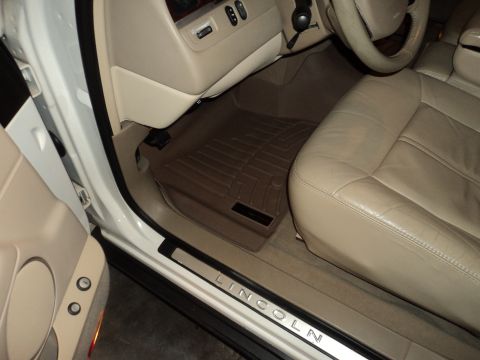 2004 Mercury Grand Marquis - The interior of a Lincoln features tan leather seats and a branded floor mat.