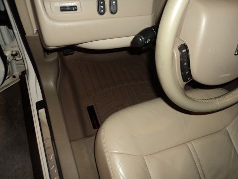 2004 Mercury Grand Marquis - Interior view of a car, showing beige leather seats and a steering wheel, with "LINCOLN" visible on the door sill.