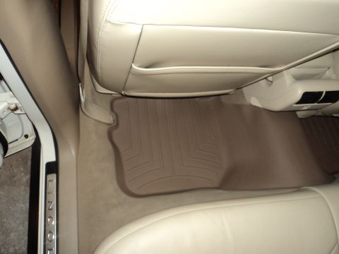 2004 Mercury Grand Marquis - The interior of a car shows beige leather seats and floor mats, with "LINCOLN" visible on the door sill.