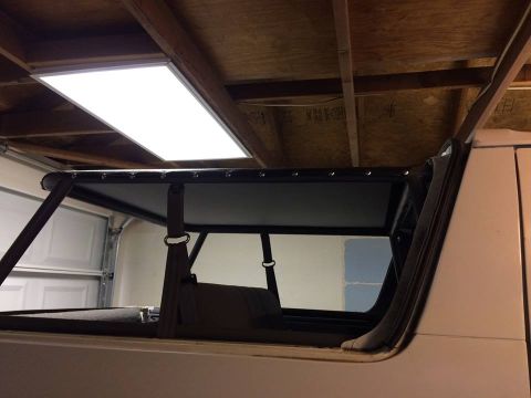 1995 Ford Bronco - The interior of a vehicle shows a custom roll cage structure installed above the seats.