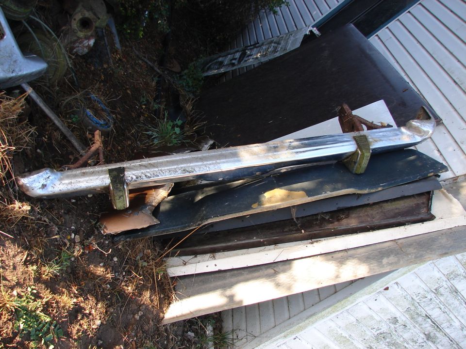 Chrome bumper and other car parts are piled up outside