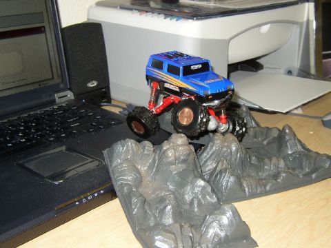 1989 Ford Bronco - Toy monster truck with oversized wheels and suspension sits on a rocky landscape accessory.