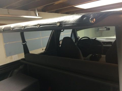 1995 Ford Bronco - Interior view showing black seats and a black soft top, with a steering wheel visible.