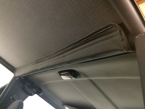 1995 Ford Bronco - Close-up of the interior headliner and roll cage in a vehicle.
