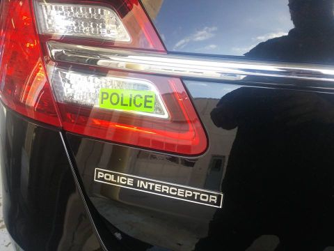 2000 Mercury Grand Marquis - Rear view of a black police interceptor sedan, a POLICE sticker and POLICE INTERCEPTOR badging.