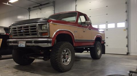 1984 Ford Bronco - This lifted 1980s Ford Bronco has a two-tone paint scheme and aggressive off-road tires.