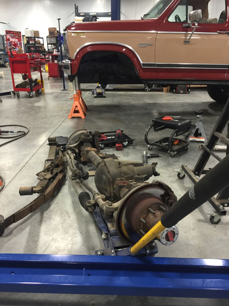 Ford Bronco front axle assembly on a lift, with the vehicle body above it