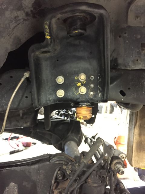 1984 Ford Bronco - Close-up view of a vehicle's suspension system, focusing on a bracket and bump stop.