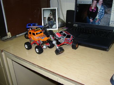 1989 Ford Bronco - Toy rock crawlers are displayed on a desk next to a laptop and a framed photo.