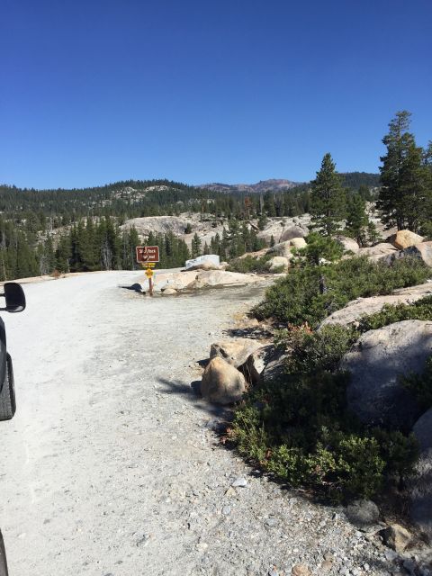 1989 Ford Bronco - A sign indicates 'Slick Rock' in a mountainous, forested area under a clear blue sky.
