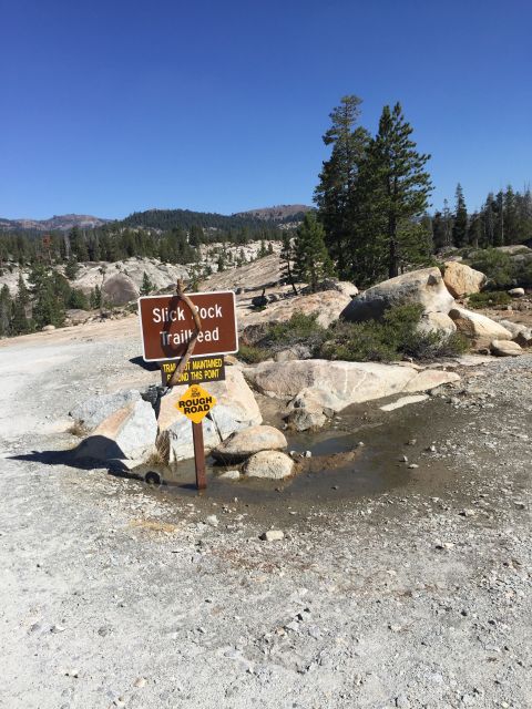 1989 Ford Bronco - A sign indicates the Slick Rock Trailhead, warning of a rough road ahead in a dry, mountainous area.