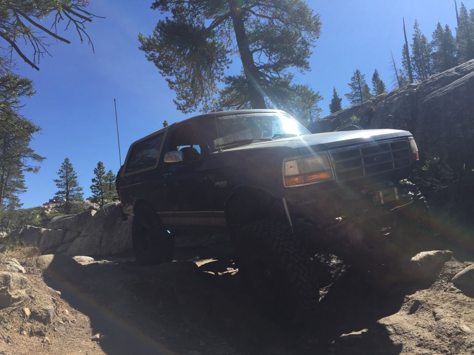 Dark 1989 Ford Bronco navigating a rocky trail