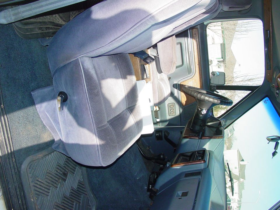 Truck interior with gray cloth seats, black steering wheel, and floor shifter