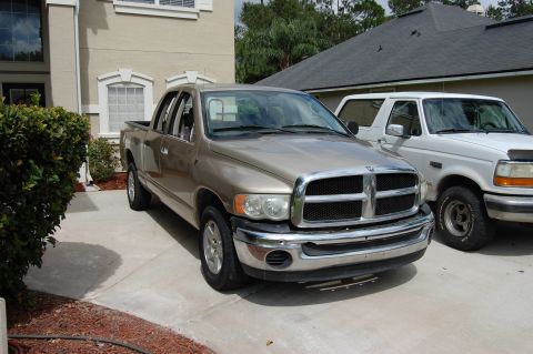 1994 Ford Bronco - Two trucks, a Dodge Ram and a Ford Bronco, are parked in a driveway.