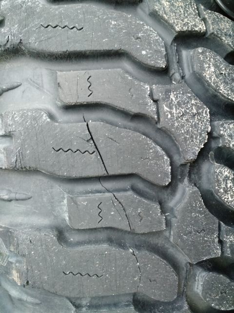 1992 Ford Bronco - Close-up of a worn tire tread showing significant cracking and sipes, with a website logo visible at the bottom.
