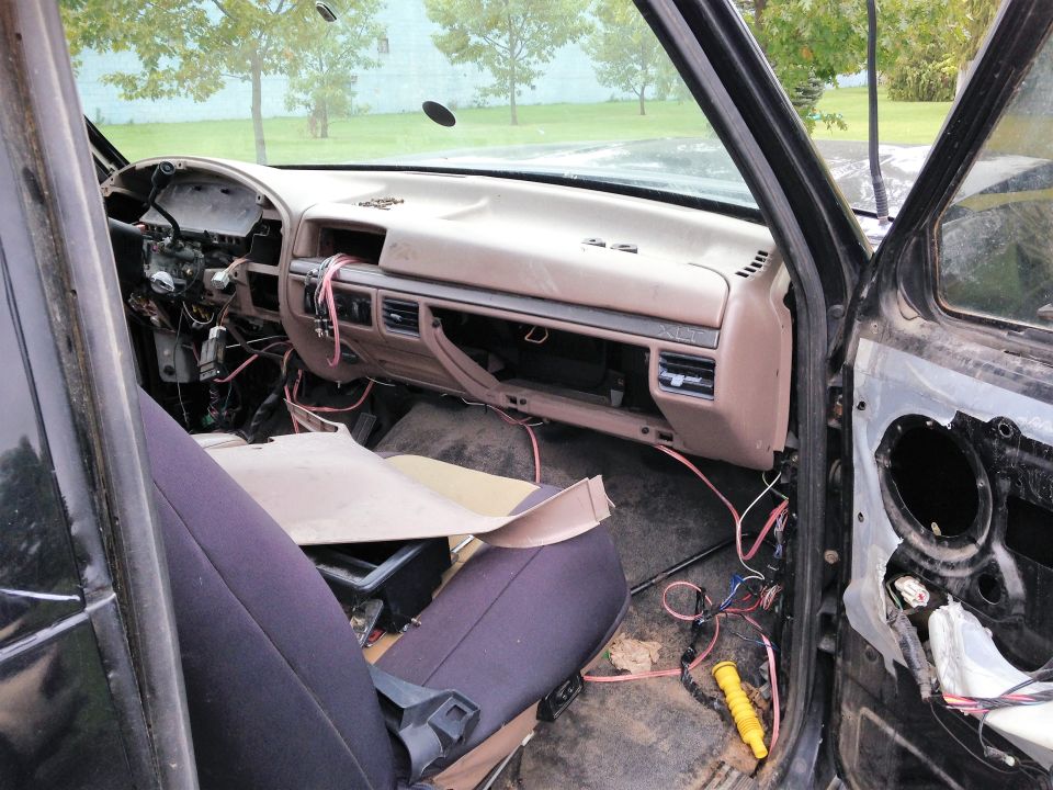 Interior of a 1992 Ford Bronco with dashboard removed and wiring exposed.