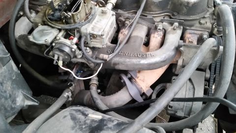 1981 Ford Bronco - A close-up view of a V8 engine's intake manifold, which is branded "EDELBROCK", and the carburetor. The engine bay is cluttered with hoses…